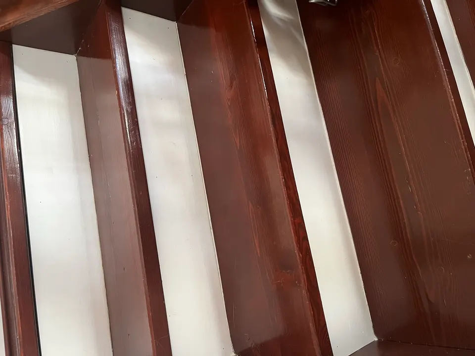 Refinished staircase with stained treads and freshly painted white risers